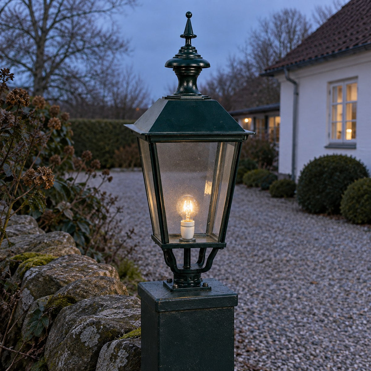 K 6 a, løs lampe, firkantet, 74 cm ved et dansk hus i aftenlys